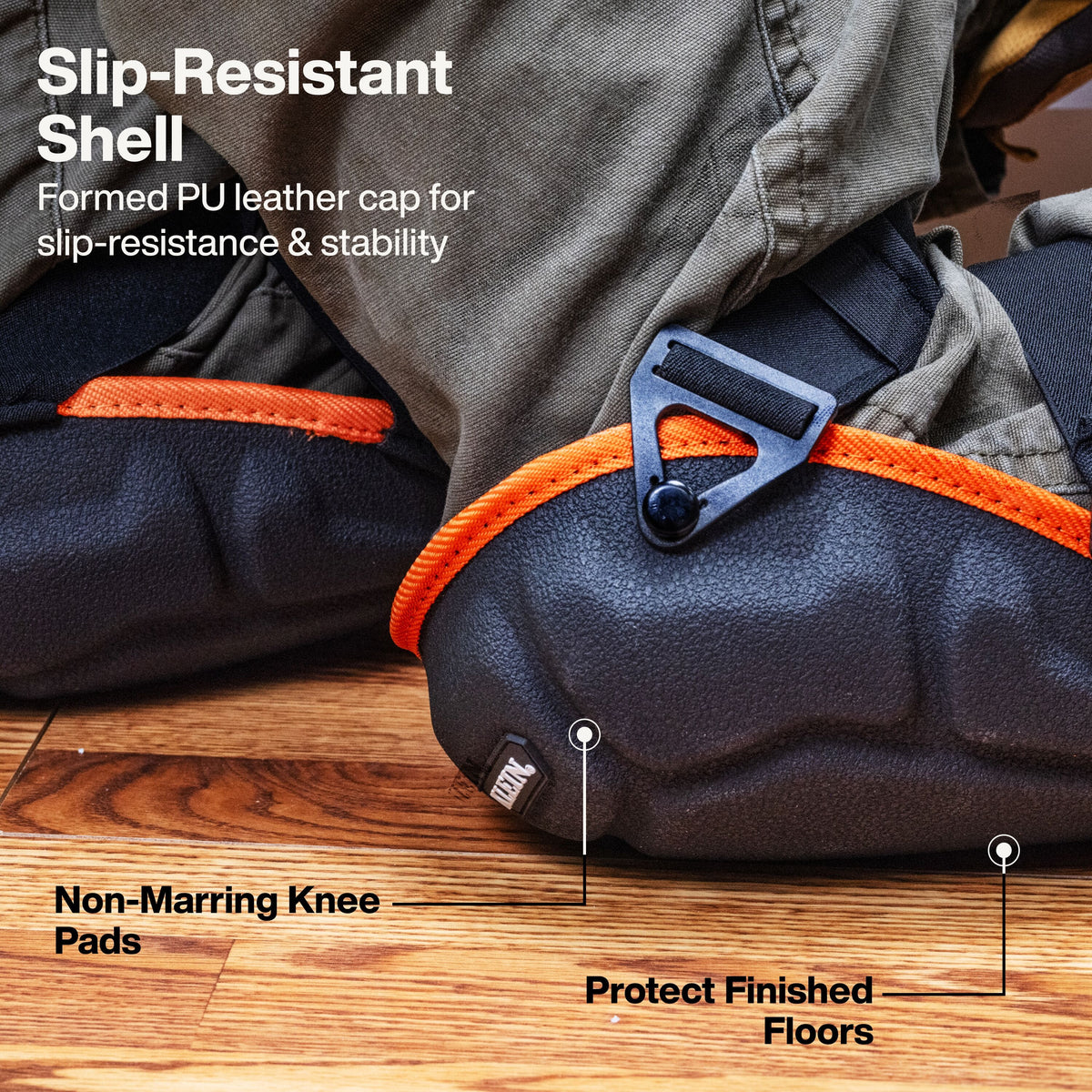 Close-up of a black knee pad with bright orange trim and a gray buckle, shown on a wooden floor with overlaid text describing slip-resistant shell, non-marring knee pads, and floor protection.