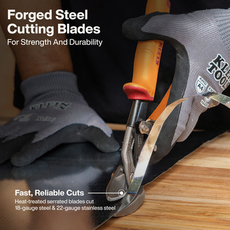 Close-up of a person wearing gray and black work gloves using a pair of KLAUEN forged steel cutting blades to cut a sheet of black material over a wooden surface. White text overlays describe the blades as forged steel, for strength and durability, and note fast, reliable cuts.