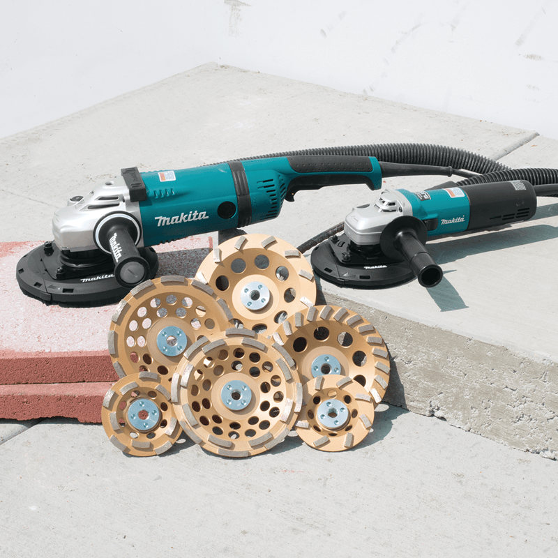 Makita angle grinder with sanding discs on a concrete surface