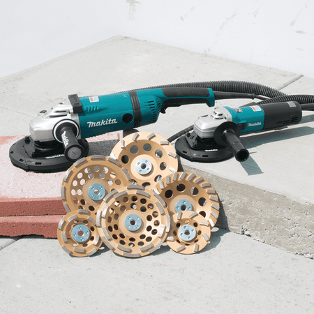 Makita angle grinder with sanding discs on a concrete surface