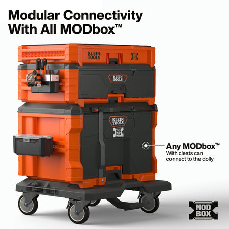 A modular tool storage dolly system by Klein Tools, shown stacked with orange and black plastic toolboxes on a wheeled base. Large text at the top reads 'Modular Connectivity With All MODbox™', and a callout on the right says 'Any MODbox™ with cleats can connect to the dolly.