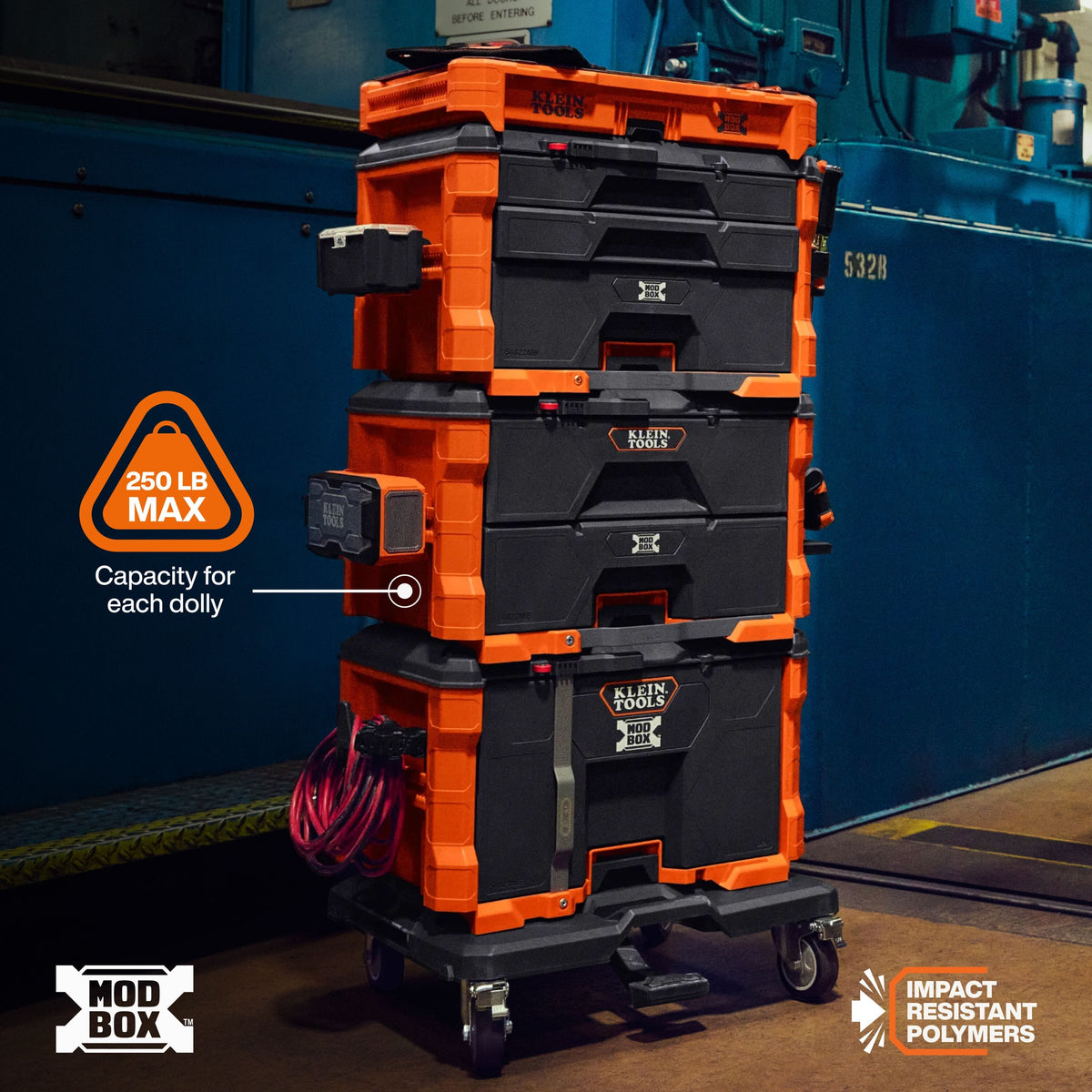 A stack of orange and black Mod Box modular dolly boxes on a wheeled base, shown in an industrial setting with a blue wall behind it. Text overlays highlight 250 LB MAX capacity and impact resistant polymers.