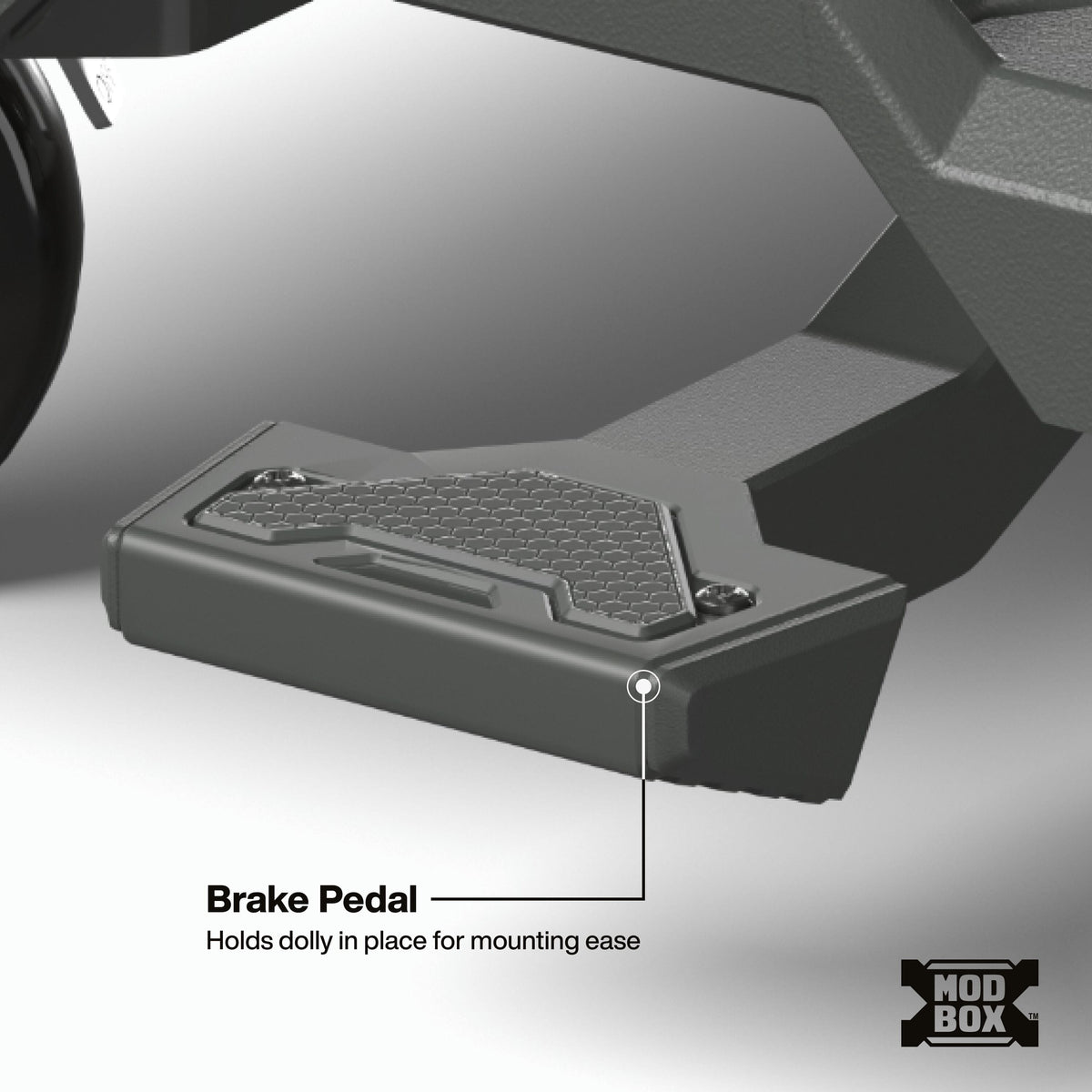 An image presents a close-up product detail of the foot brake pedal mechanism on the heavy-duty base of a Klein Tools MODbox™ rolling dolly.   