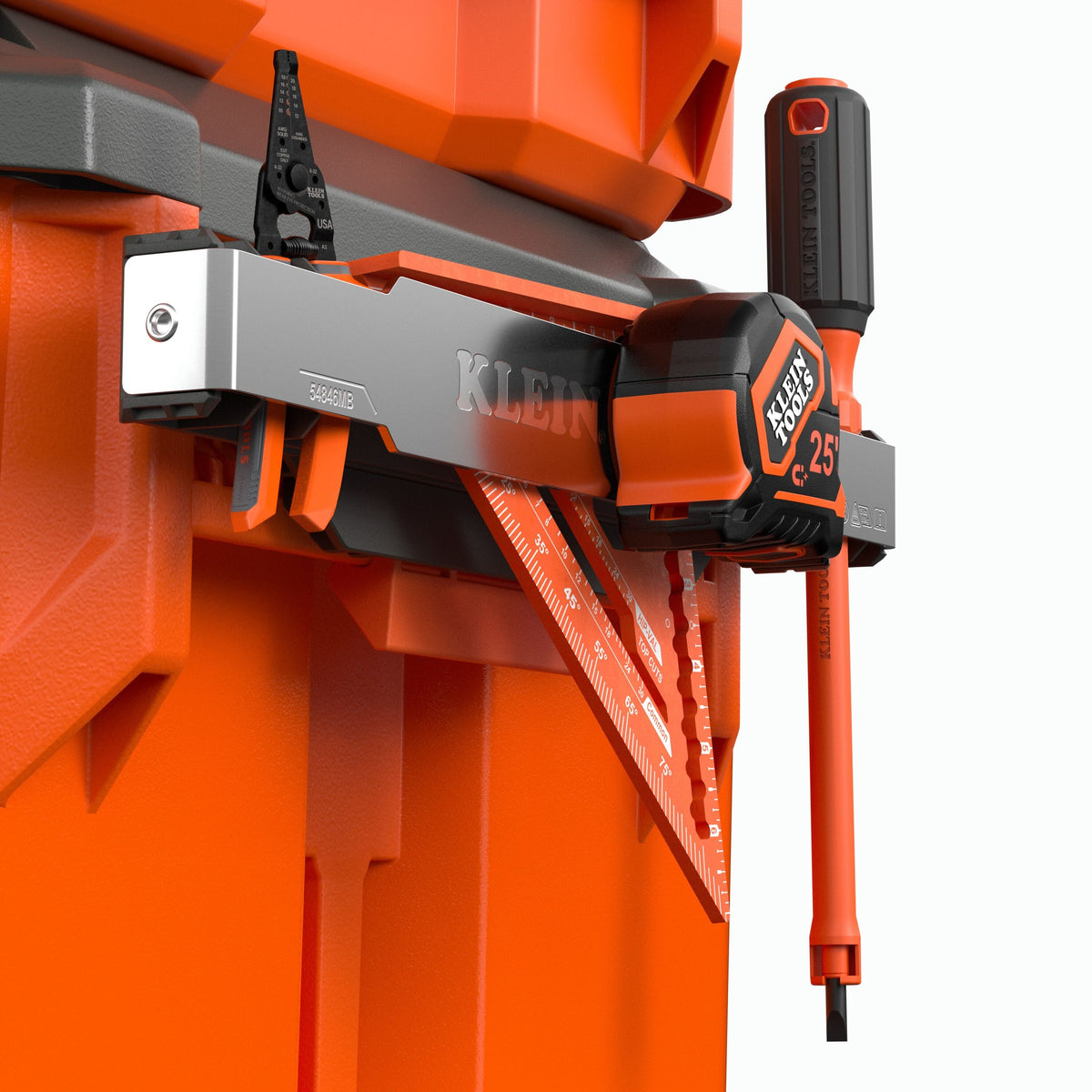 Klein tool organizer mounted on an orange storage unit, holding a black and orange screwdriver, a red triangular ruler, and a black-and-silver level against a white background.