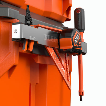 Klein tool organizer mounted on an orange storage unit, holding a black and orange screwdriver, a red triangular ruler, and a black-and-silver level against a white background.
