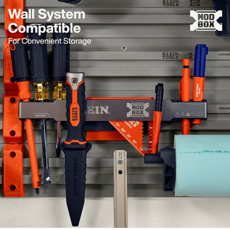 Klein Tools Mod Box wall-mounted tool organizer rack shown installed on a gray pegboard with various hand tools hanging in orange, black, blue, and silver. White text in the top left reads 'Wall System Compatible For Convenient Storage' and a Klein Tools logo is visible.
