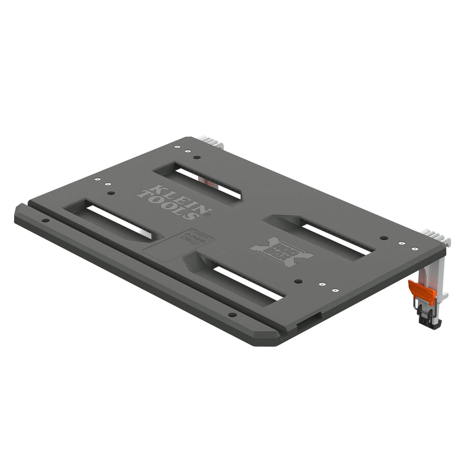 An image displays an isolated product rendering of a dark-gray modular adapter plate or mounting shelf from the Klein Tools MODbox™ modular storage system, angled in a three-quarters perspective against a clean white background.   