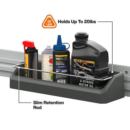 A dark gray metal wall-mounted storage tray shown mounted on a silver rail, holding several automotive products including a black 2-stroke motor oil bottle, a black spray can, and a blue squeeze bottle. Text callouts read 'Slim Retention Rod,' 'Holds Up To 20lbs,' and '20 LBS,' on a white background.