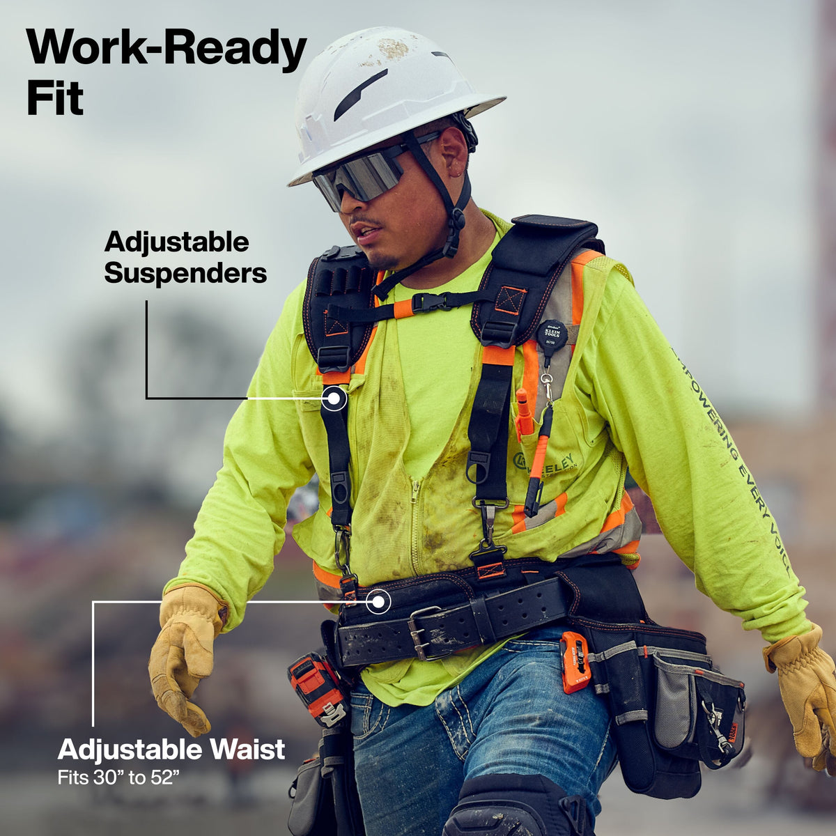 Person wearing a safety harness with adjustable suspenders and waist, on a blurred background.