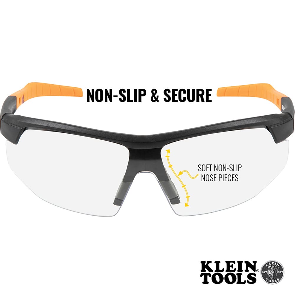 Safety glasses with orange and black frame on a white background, featuring Klein Tools branding.