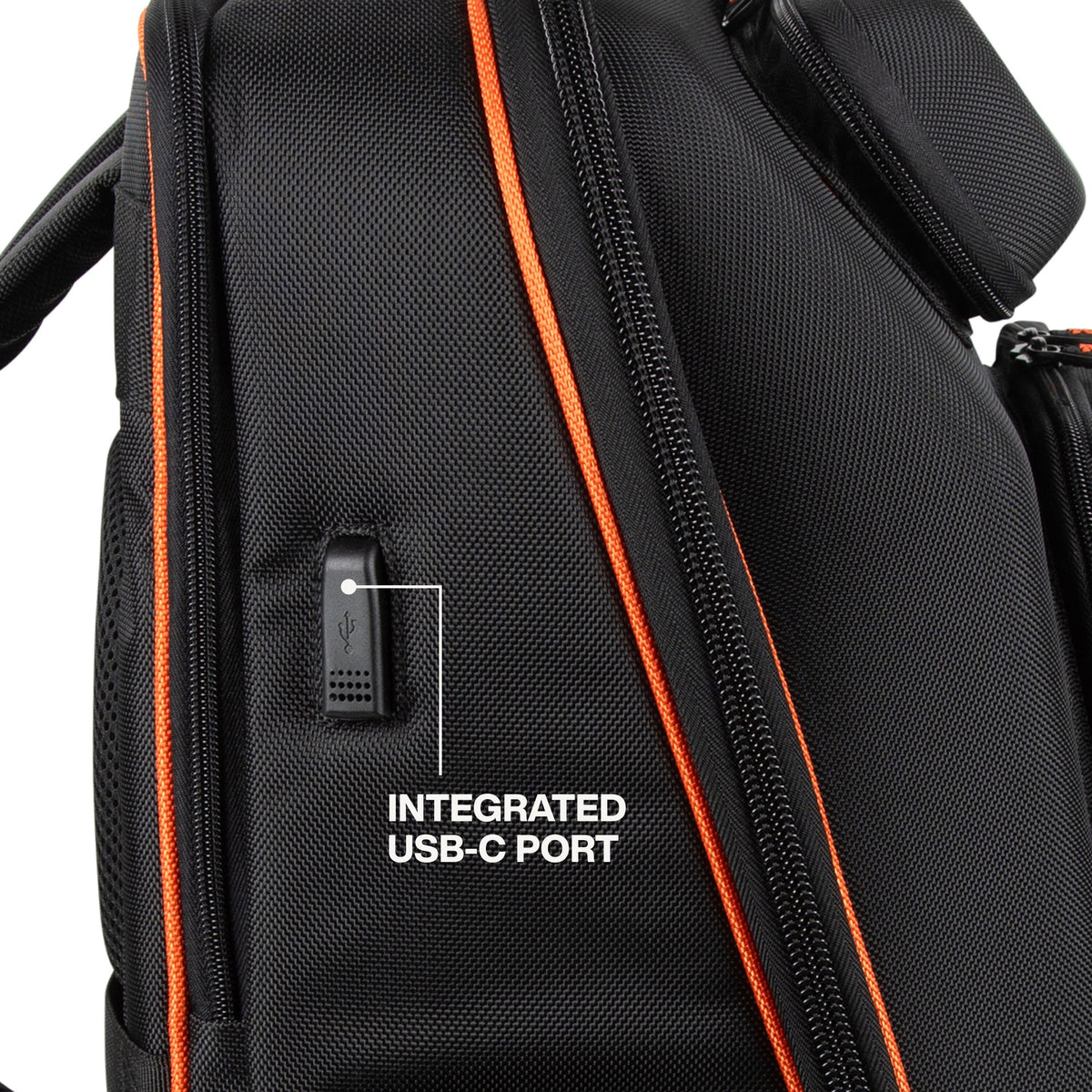 Close-up of a black backpack with orange zipper trim and a white text overlay pointing to an integrated USB-C port.