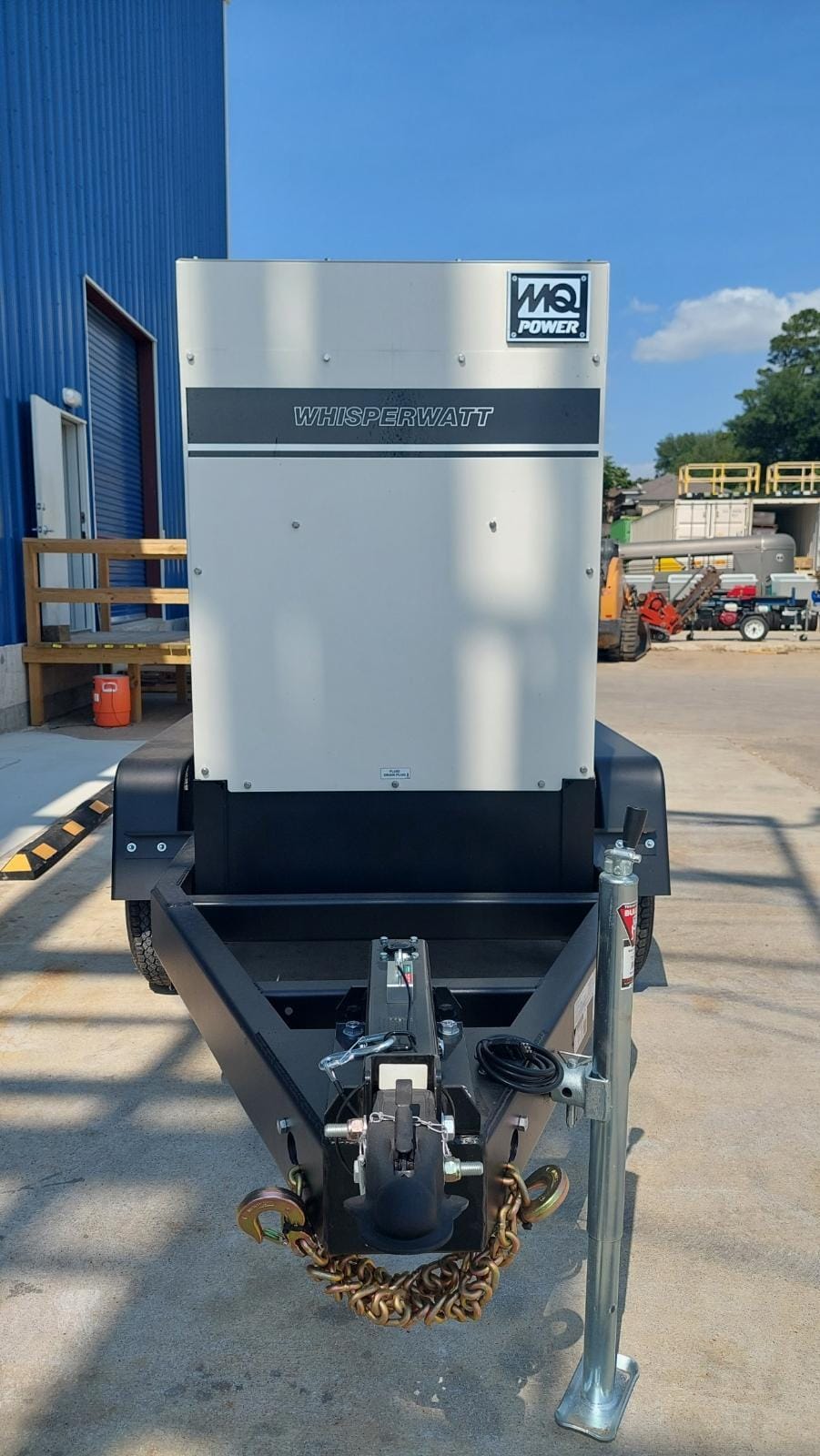 Facing the front of the generator and trailker, With blue skies in the background.