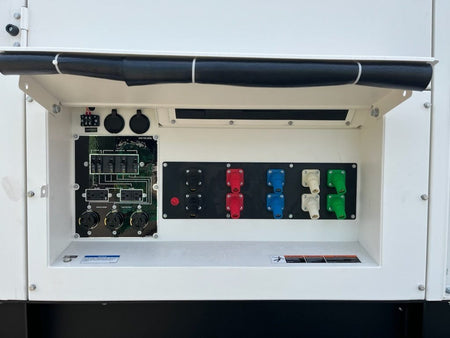 A view of the power output connections on the MQ Power generator. It shows a panel with multiple outlets of different types and colors, along with circuit breakers and wiring diagrams, all housed within a white enclosure.
