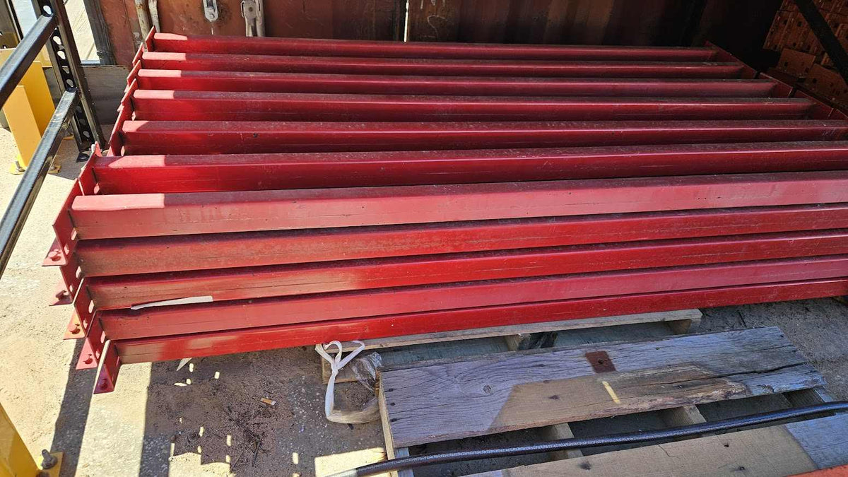 A stack of industrial teardrop pallet rack step beams in used like new condition featuring a durable red finish and a 3.5-inch face height for heavy-duty 6-foot warehouse storage racking.