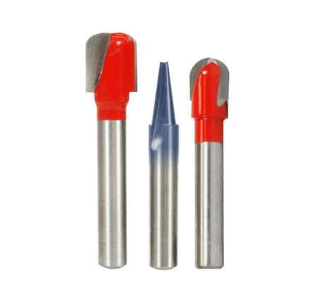 The three router bits from the Freud Lettering and Sign Making set standing upright: two red-coated round nose/dish carving bits, and one blue-coated engraving V-groove bit.
