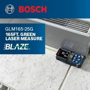 The Bosch BLAZE GLM165-25G laser measure resting on a tiled floor, projecting its green laser line to a wall for an accurate measurement.