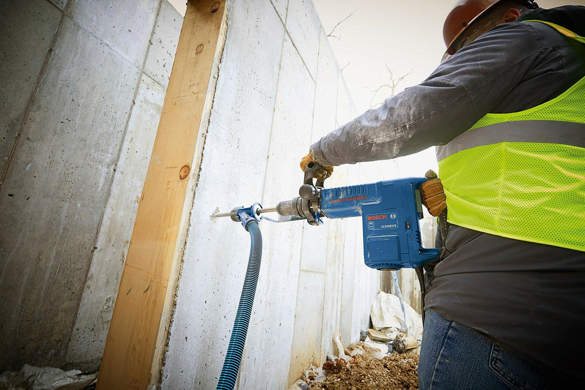 Person using a blue hose and tool in a construction setting