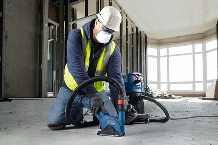 BOSCH DB1041S 10-Inch Segmented Rim Diamond Blade cutting concrete floor by worker with safety gear