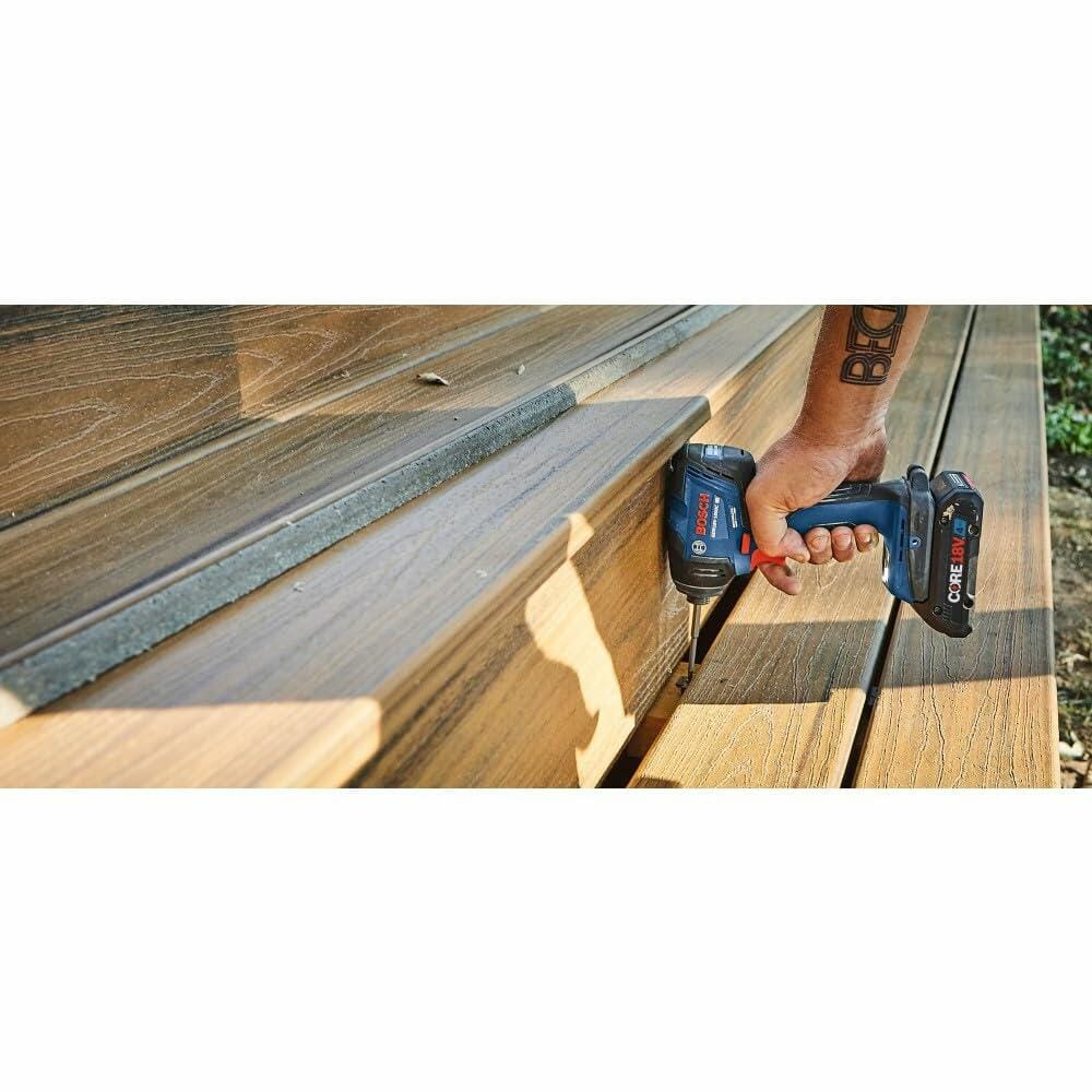 A person using the Bosch GDR18V-1860C impact driver to fasten a screw into composite decking material during outdoor construction.