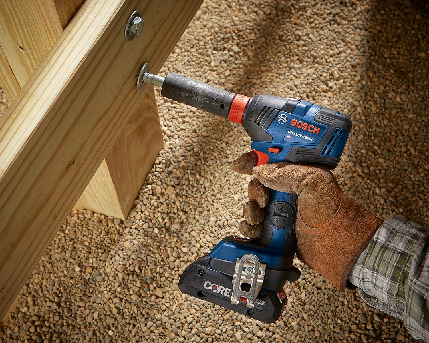 Gloved hand using the Bosch GDX18V‑1800C reconditioned 18V brushless impact driver to tighten a large bolt into a wooden structure, showcasing high‑torque performance in construction settings.