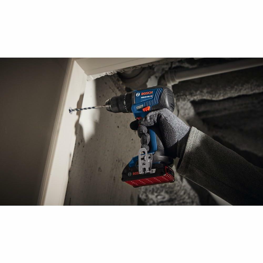 Person using a Bosch CORE18V cordless drill to install a hinge on a white door frame. The drill is shown driving a screw, highlighting its utility in home improvement and carpentry tasks.