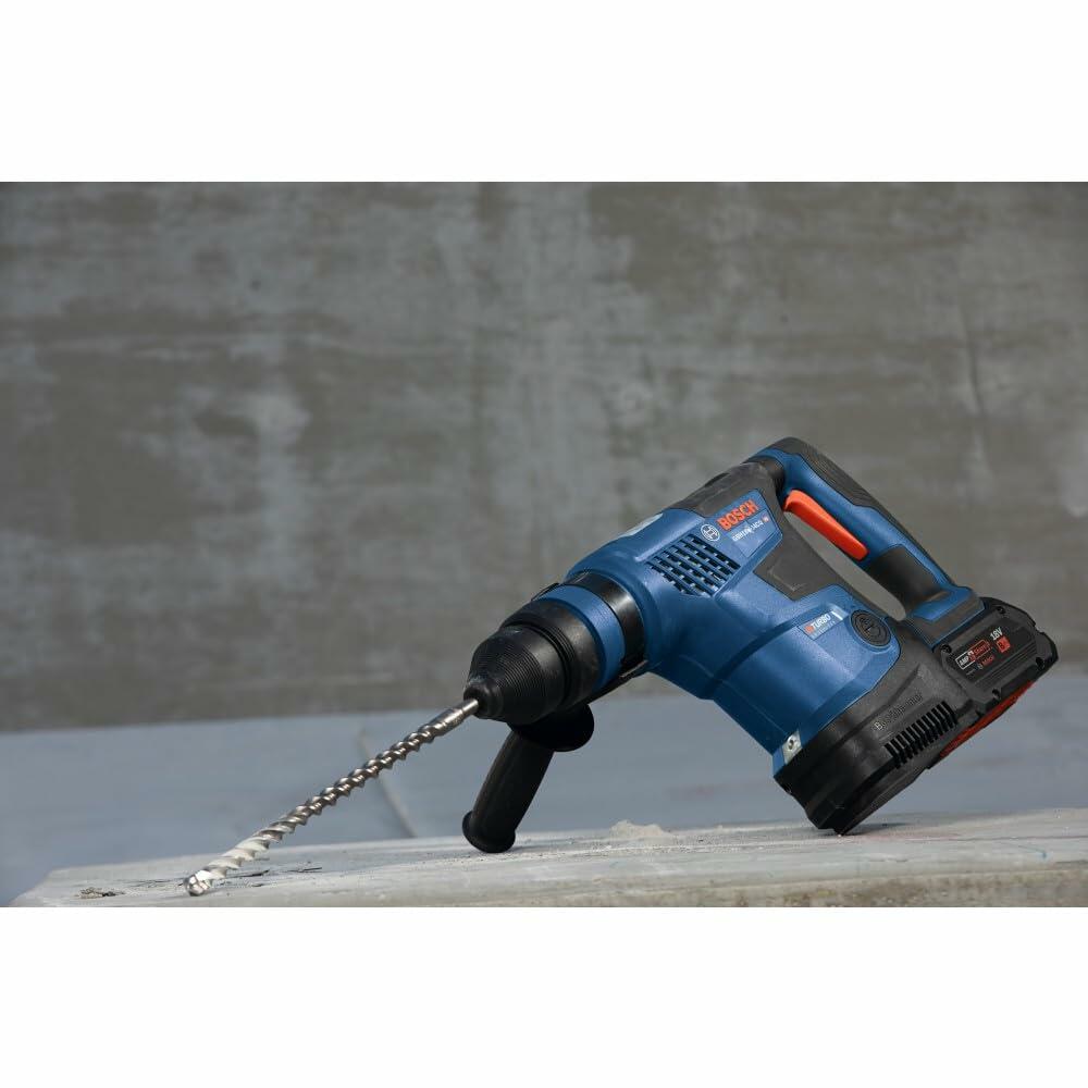 The Bosch PROFACTOR Bulldog rotary hammer with a carbide drill bit inserted, resting on a concrete surface at a jobsite.