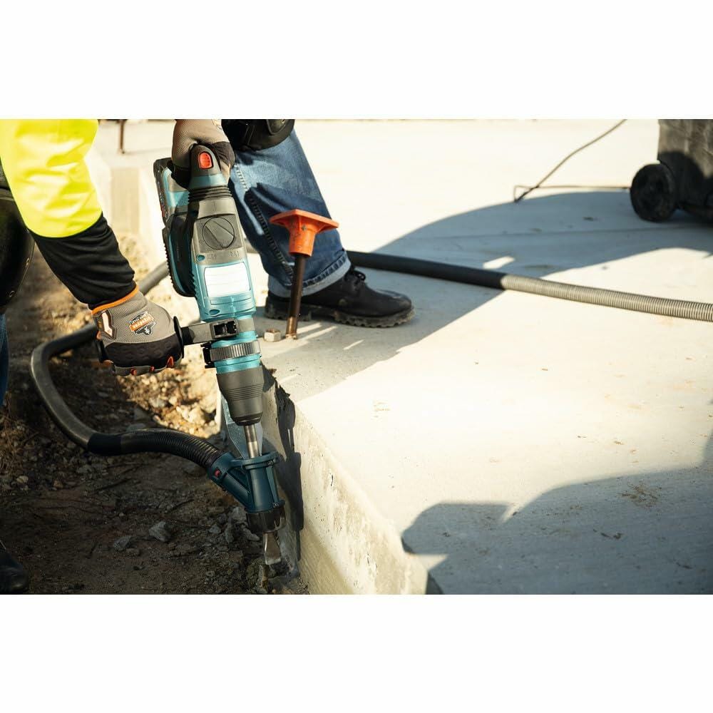 A worker uses the Bosch rotary hammer with a chisel bit and an attached dust extraction hose to chip away at a concrete curb.