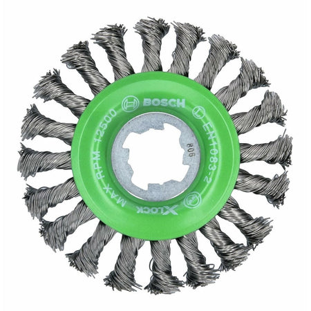 A circular wire brush wheel is shown head-on, featuring a bright green hub at its center. Twisted tufts of silver metallic wires radiate outwards from the hub like spokes, and the hub is marked with the Bosch logo and a maximum RPM rating.