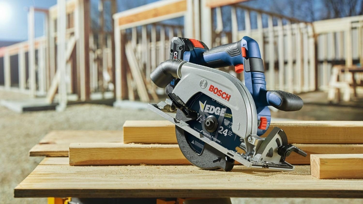 qxQKZq2FvbnZ8vF8K1QMZ.jpeg
Bosch EDGE 24-tooth circular saw placed on stacked wooden planks at a construction site, with partially built framing in the background.

