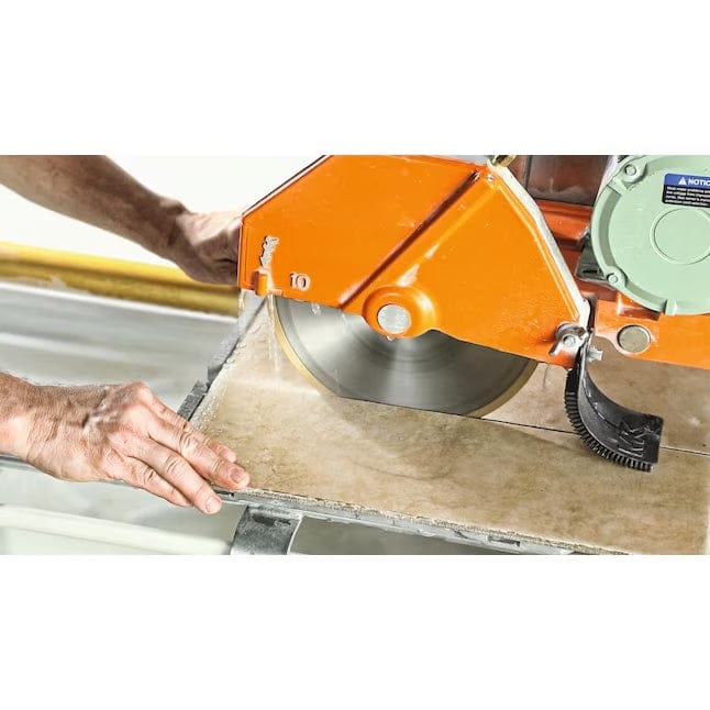A person using a wet tile saw equipped with the Bosch DB1043S diamond blade to cut a large ceramic tile.