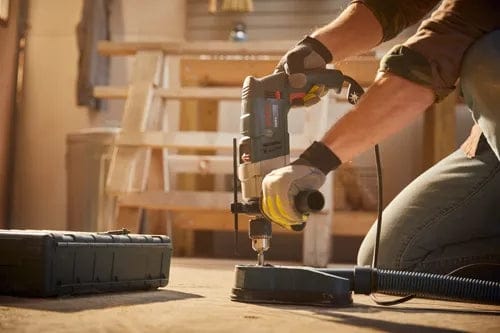 The Bosch HD18-2 hammer drill is shown mounted on a dust extraction stand for clean, precise drilling.