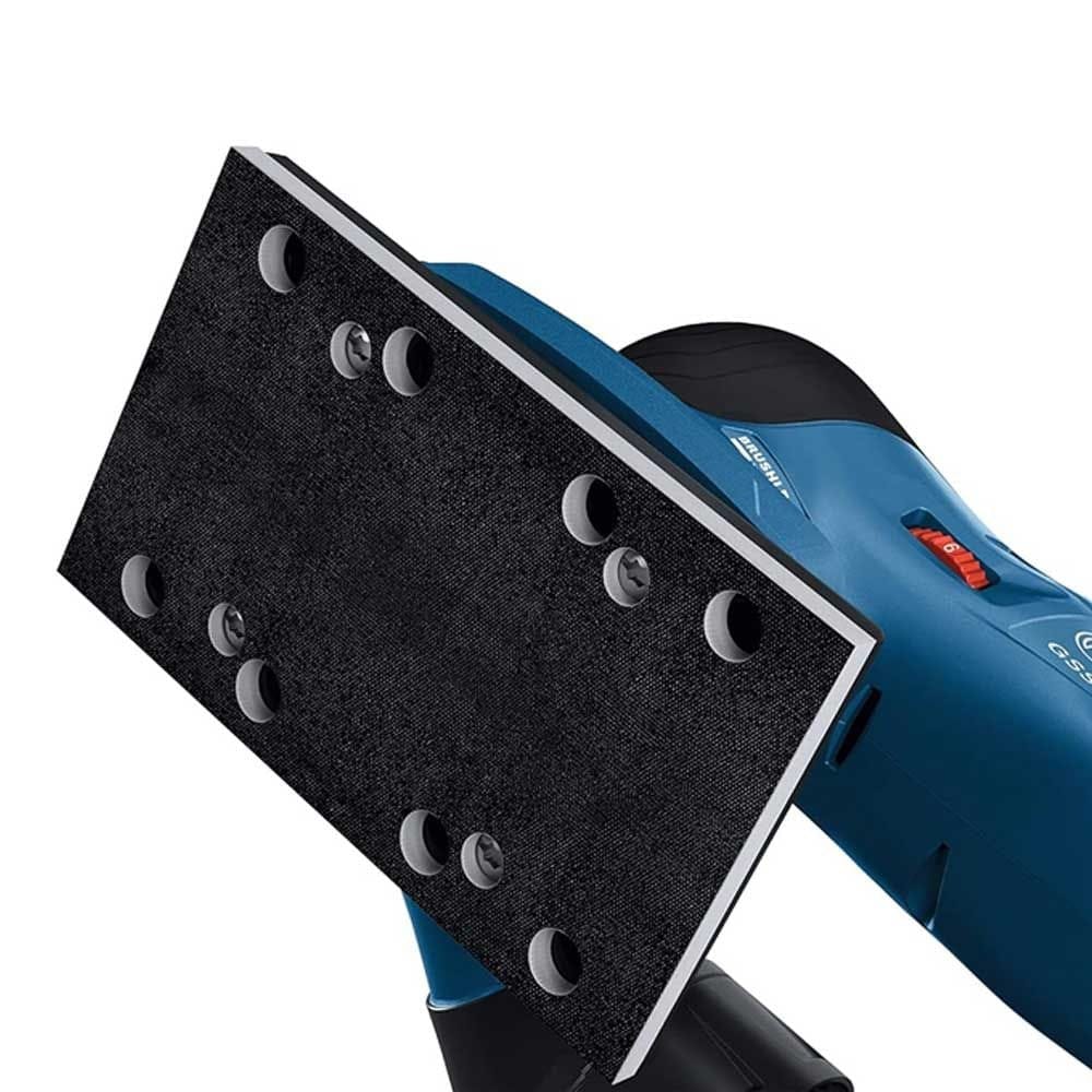 Detail view of Bosch sander’s rectangular sanding pad with dust extraction holes; red switch and black handle visible.