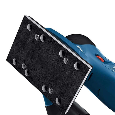 Detail view of Bosch sander’s rectangular sanding pad with dust extraction holes; red switch and black handle visible.