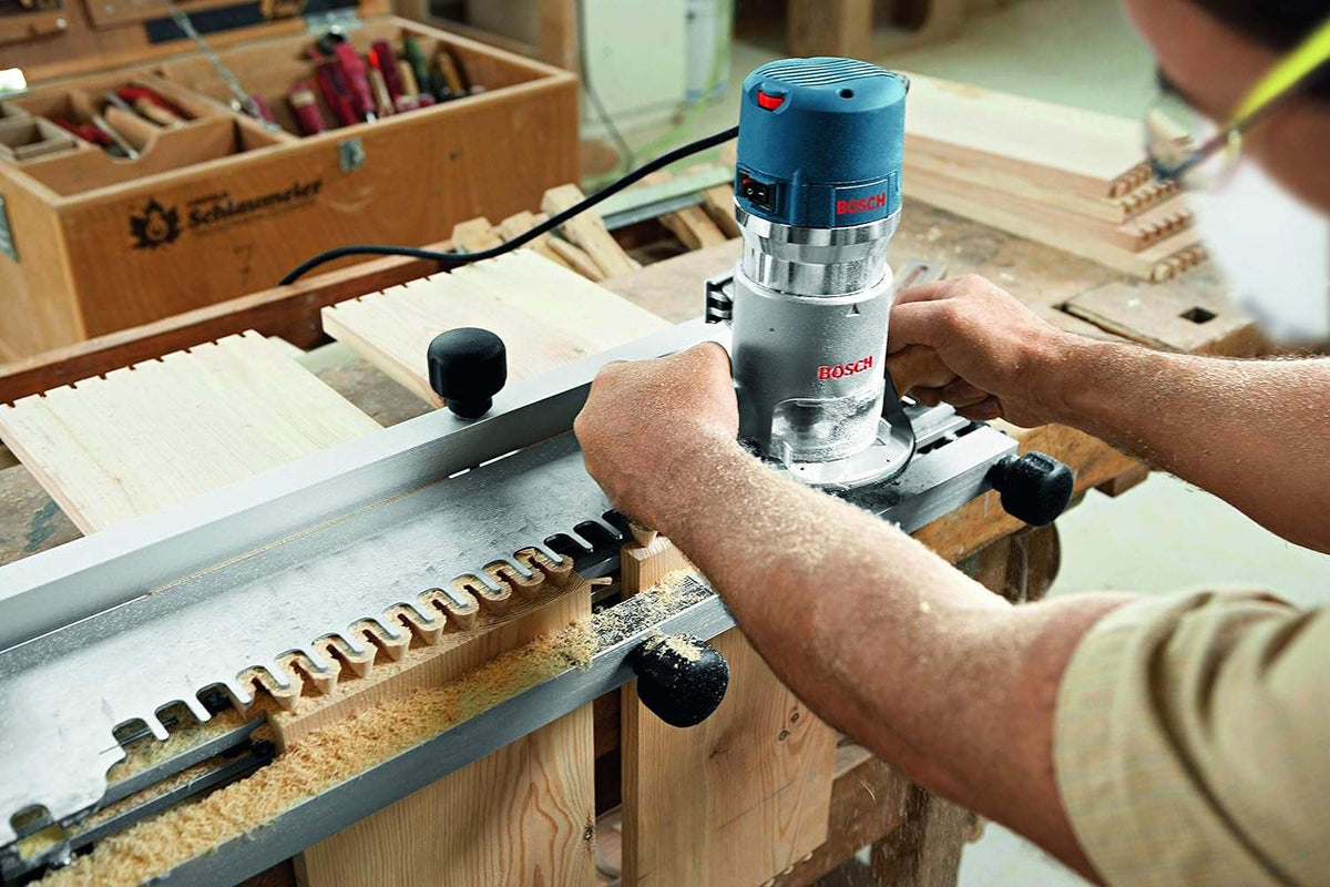 Construction professional using the Bosch 1617EVS-46 fixed-base router with a dovetail jig template to create high-quality interlocking wood joints for cabinetry.