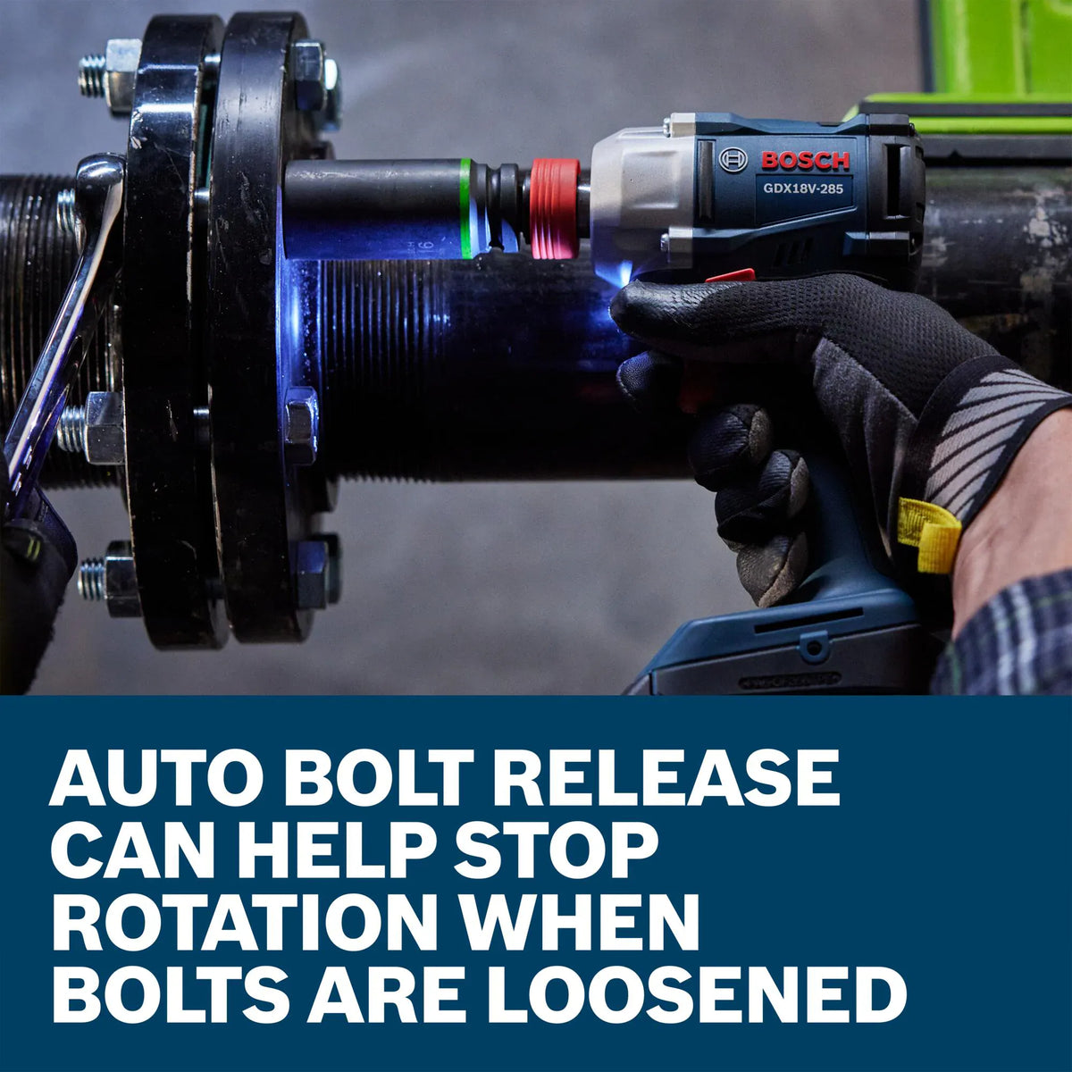A mechanic wearing a padded work glove uses the Bosch 18V cordless impact wrench tool to tighten structural hardware bolts on a heavy black industrial machinery flange. A descriptive product banner along the base notes that an automatic bolt release feature can help stop tool rotation as soon as bolts are fully loosened.