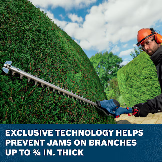 A yard care professional trims the curved side of a large ornamental evergreen shrub using the Bosch 18V brushless pole hedge trimmer. The lower text box notes that the tool's exclusive anti-blocking technology system helps prevent blade jams on branches up to 3/4-inch thick.