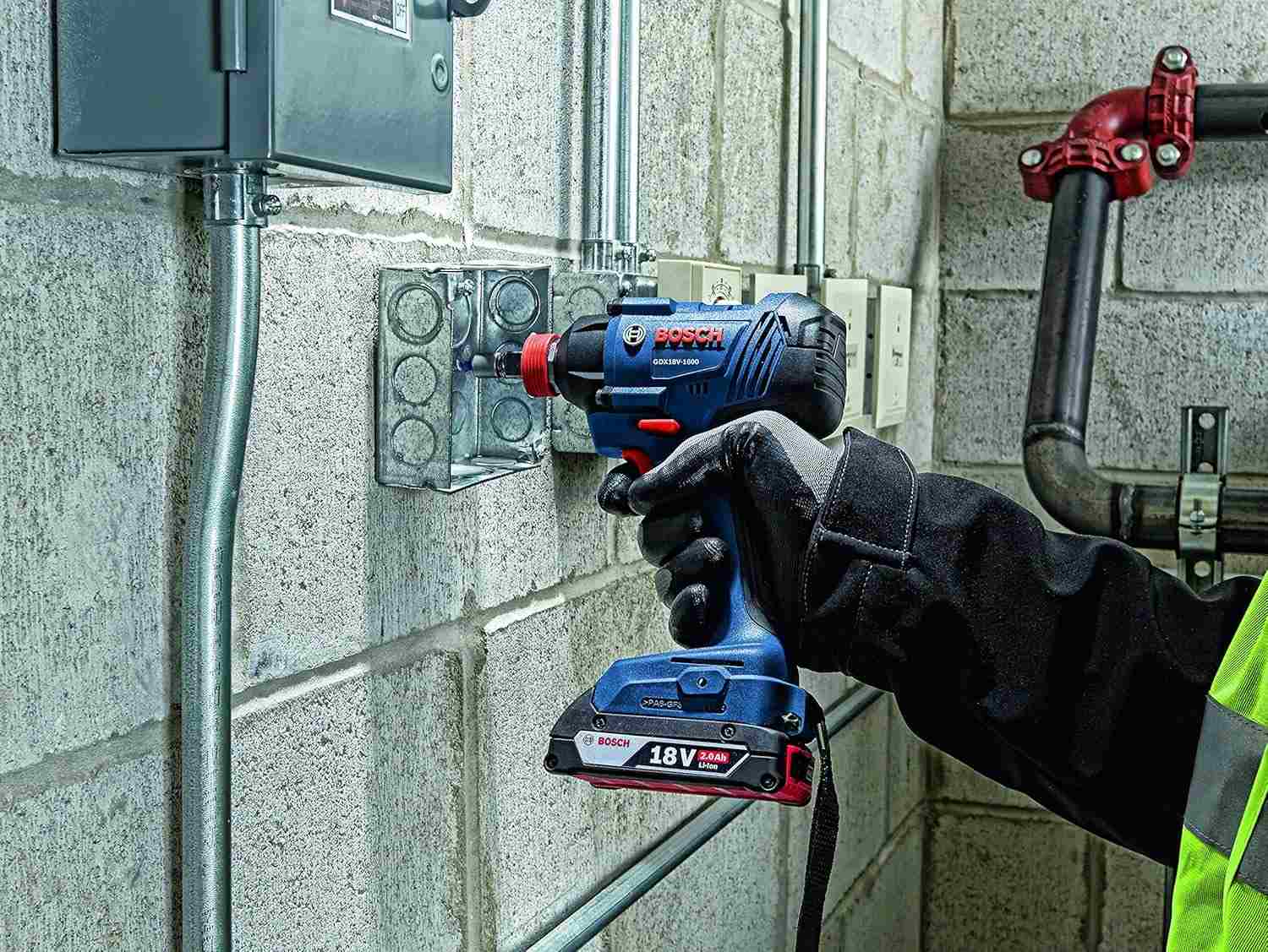 Installer using a Bosch 18V cordless drill driver to mount an electrical box on a concrete wall, showcasing strong drilling power, lithium‑ion efficiency, and professional‑grade durability for electrical and industrial construction environments.