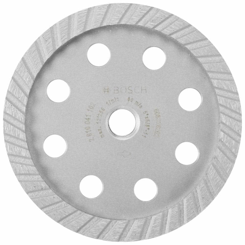 Bosch 5-inch Pro Turbo Diamond Cup Wheel model DC530SG shown from above. The metal grinding wheel features a diamond-coated rim and multiple cooling holes around the center. Designed for use with surface grinders, it delivers a smooth, polished finish on concrete. Text on the wheel includes product specifications such as “max. 13,300 min⁻¹,” “80 m/s,” and “Ø 115 x 22.23 mm.”