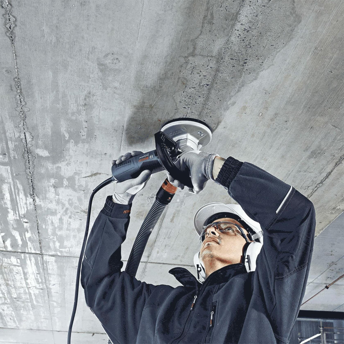 BOSCH DC730H 7 In. Turbo Row Diamond Cup Wheel with 5/8"-11 Hub used on angle grinder for concrete surface preparation.