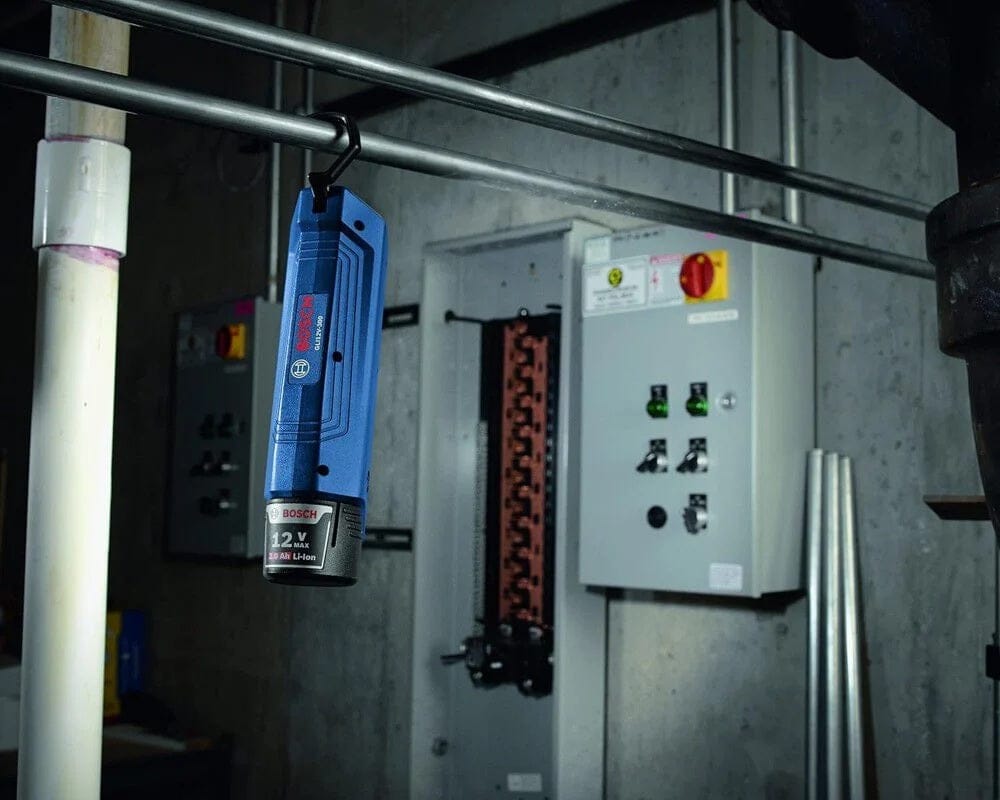 A Bosch 12V LED work light hanging from a metal pipe in a utility room, powered by the BAT414 12V Max battery.