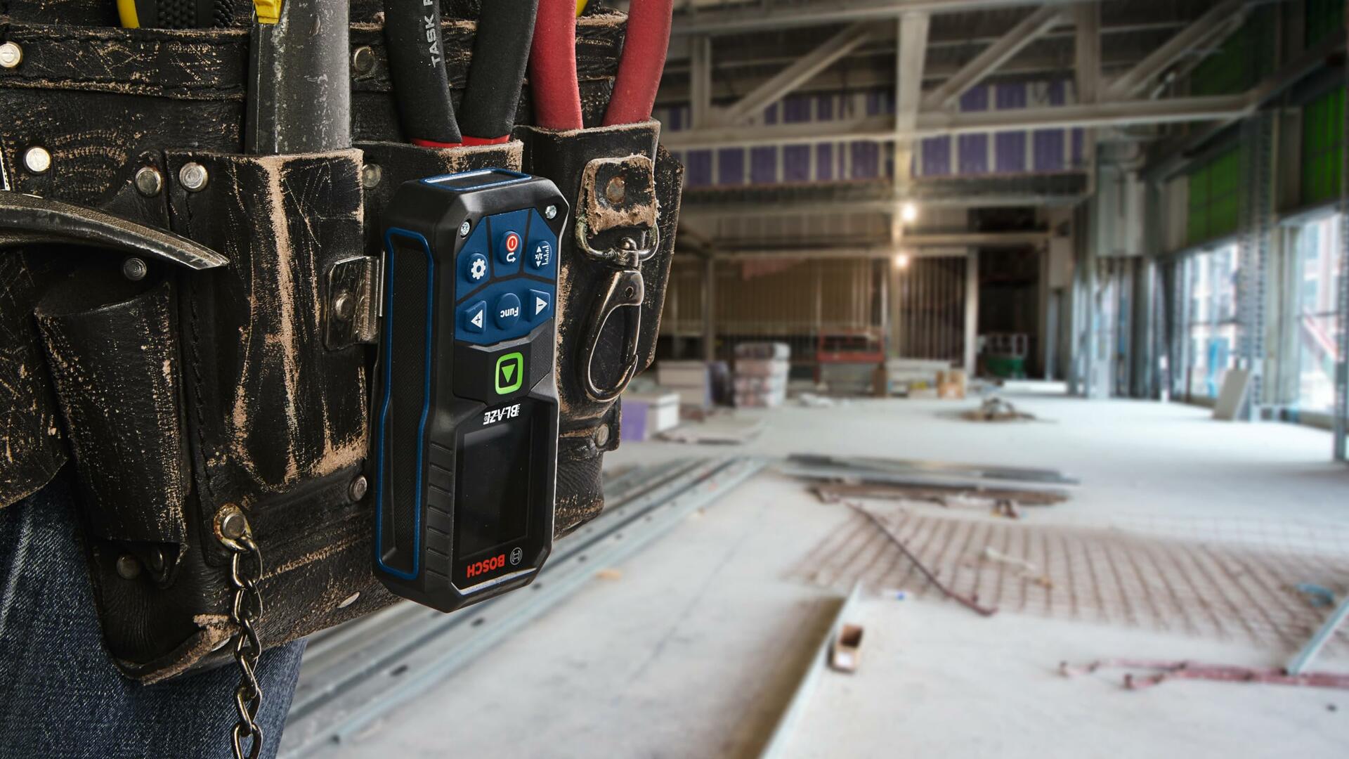 Action shot showing the Bosch GLM165-27CGL laser measure securely clipped to a worker's tool belt, illustrating the use of the belt clip for convenient jobsite portability