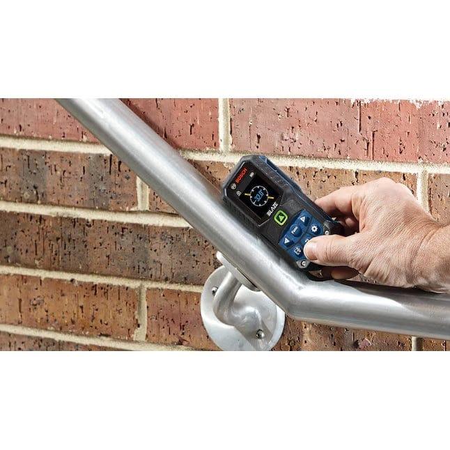Action shot showing the Bosch GLM165-27CG laser measure held against a sloping metal handrail, demonstrating the inclinometer function being used to read the tilt angle