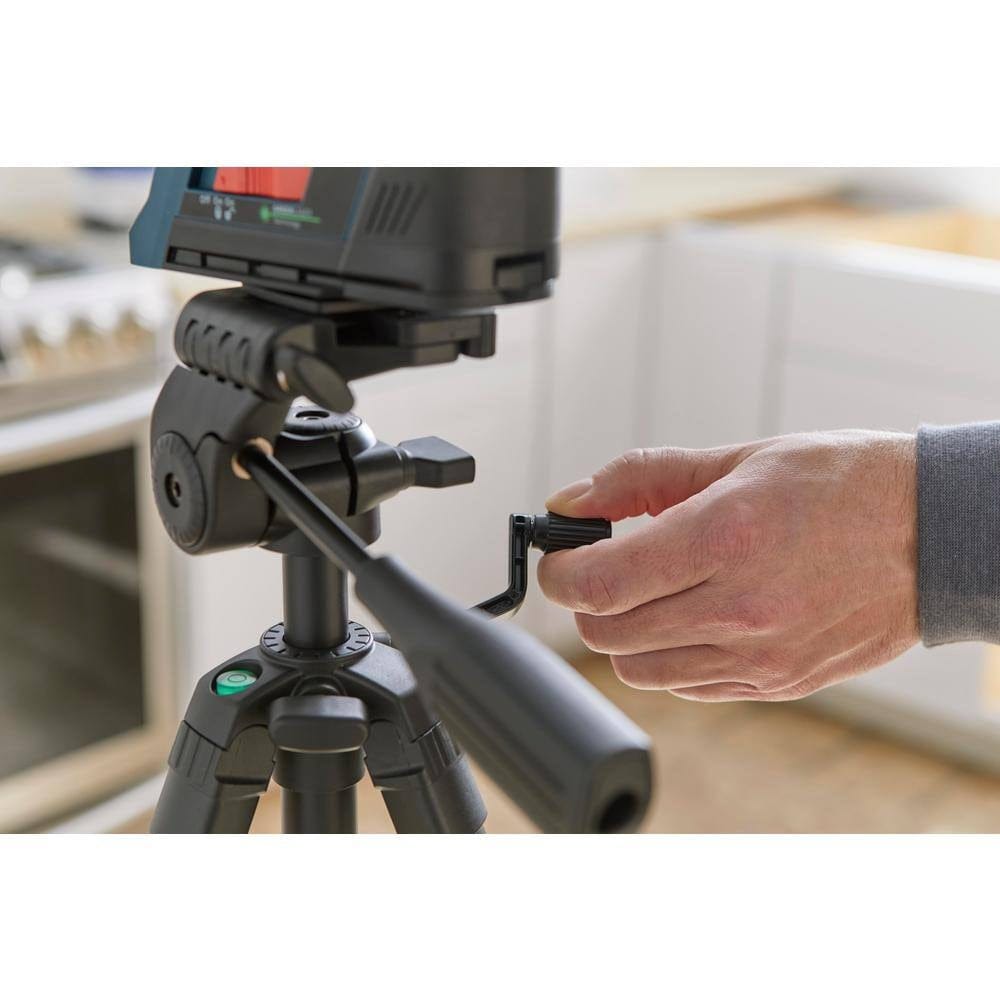 Close-up of hand adjusting crank handle on Bosch BT 150 tripod in kitchen setting for height control.