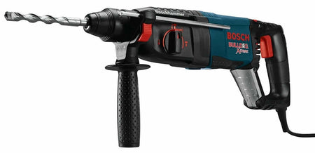 A three-quarter profile view of the Bosch Bulldog Xtreme rotary hammer, showing the D-handle, auxiliary handle, and an SDS-plus bit inserted into the chuck.