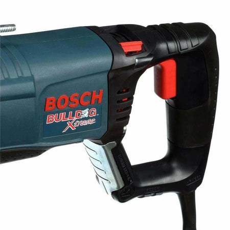 A close-up view of the D-handle on the Bosch Bulldog rotary hammer, showing the red variable-speed trigger and the HammerHook storage clip.