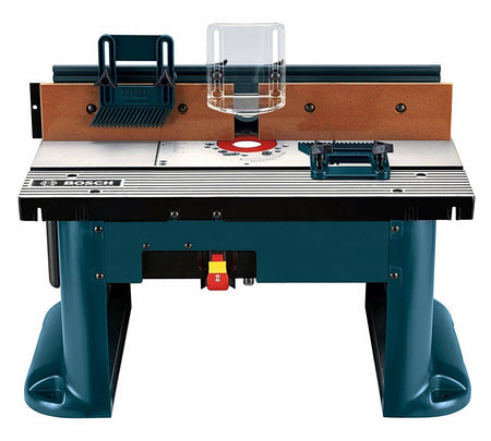 Front straight-on studio view of the Bosch RA1181 benchtop router table highlighting the tall fence assembly, integrated featherboards, and the front-mounted power switch with safety lock