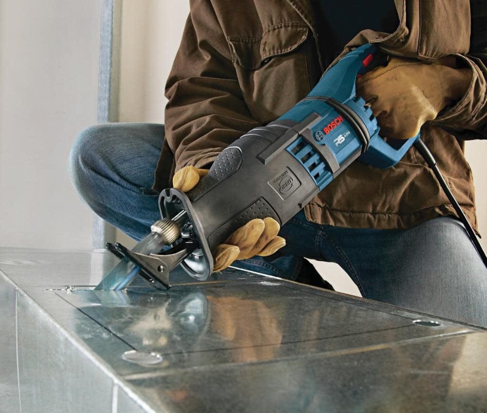 Action shot of a worker using the reciprocating saw blade to cut a rectangular opening in galvanized sheet metal ductwork.