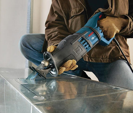 Action shot of a worker using the reciprocating saw blade to cut a rectangular opening in galvanized sheet metal ductwork.