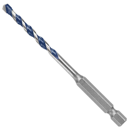 An isolated product studio layout of a short, thick-diameter Bosch Blue Xtreme masonry drill bit resting diagonally against a clean white background, showcasing its standard 1/4-inch power groove hex shank base, a short metal body shaft, blue-painted spiral flutes, and a robust carbide centering tip.
