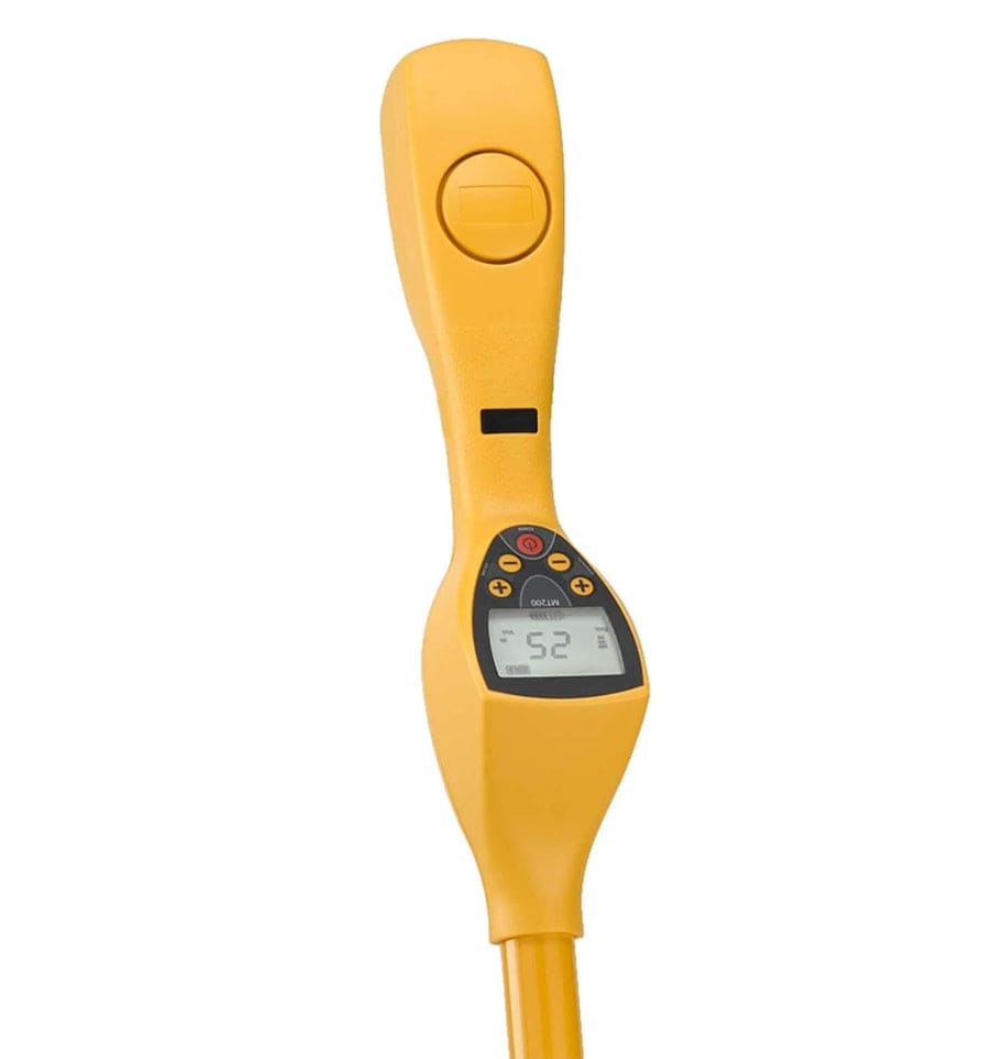 A top-down perspective of the yellow magnetic locator housing, highlighting the ergonomic handle, power line indicator warning area, and the digital display unit.